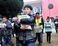 2016年1月8日下午,在駐馬店市汝南縣三門閘街道大新莊小學(xué)校院內(nèi)，駐馬店市陽光助學(xué)協(xié)會(huì)負(fù)責(zé)人及志愿者、大新莊學(xué)校師生、學(xué)生家長(zhǎng)歡聚一堂，舉行了“陽光助學(xué)愛心圖書室”捐贈(zèng)儀式。圖為學(xué)生和志愿者一起搬運(yùn)新書