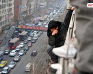 圖為2014年1月3日，蘭州，6名農(nóng)民工為了討薪爬上白銀路一居民樓9樓平臺要“跳樓”。原來，該樓4層的甘肅天安建筑機(jī)械工程公司拖欠24名工人的24萬元工錢，他們討要5個(gè)月毫無結(jié)果，便做出危險(xiǎn)之舉。后經(jīng)有關(guān)部門多方協(xié)調(diào)，工人們當(dāng)場拿到了18萬元。于永昭/視覺中國