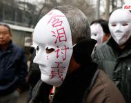 近幾年，由于經(jīng)濟(jì)增速下行，中西部地區(qū)和中小城市成為當(dāng)前討薪矛盾多發(fā)地區(qū)。一邊是國家和地方維護(hù)打工者權(quán)益的法律法規(guī)不斷出臺，另一邊則是“年年干活年年欠，年年討薪年年難”。不少打工者不得已只好采取行為藝術(shù)等手段以博取關(guān)注。圖為2015年2月2日，西安市尚德路陜西省水利廳的門前，七八位頭戴著白色面具者站在凜凜寒風(fēng)中，面具上寫著：“含淚討工錢” “無顏見父母”等標(biāo)語。據(jù)了解，這幾個(gè)人是70名農(nóng)民工的代表，他們之前在武功縣干的工程被欠款156萬元。誰知，包工頭不但電話打不通，以前的家也搬了，根本找不到人，多次找到水