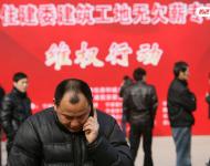 2013年1月27日，寧波市住建委“建筑工地?zé)o欠薪專項(xiàng)維權(quán)行動”在寧波書城外廣場舉行，20余家大型建筑企業(yè)負(fù)責(zé)人現(xiàn)場辦公，對討薪工人涉及的問題現(xiàn)場進(jìn)行解答，確保工人及時(shí)拿到工錢，開心回家過春節(jié)。圖為一位工人在打電話。張培堅(jiān)/視覺中國