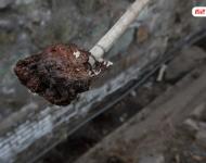 在遷安市中化煤化工有限責(zé)任公司的圍墻外是污水排放溝，溝里的泥成為紅褐色。