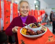 1月4日，內(nèi)蒙古呼和浩特市玉泉區(qū)清泉街社區(qū)一位老人在展示臘八粥食材。當(dāng)日，呼和浩特市玉泉區(qū)清泉街社區(qū)舉辦“溫暖臘八粥 濃濃鄰里情”活動，喜迎即將到來的“臘八節(jié)”。新華社發(fā) 丁根厚 攝